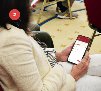 Persona usando un smartphone para acceder a la plataforma de votación digital.
